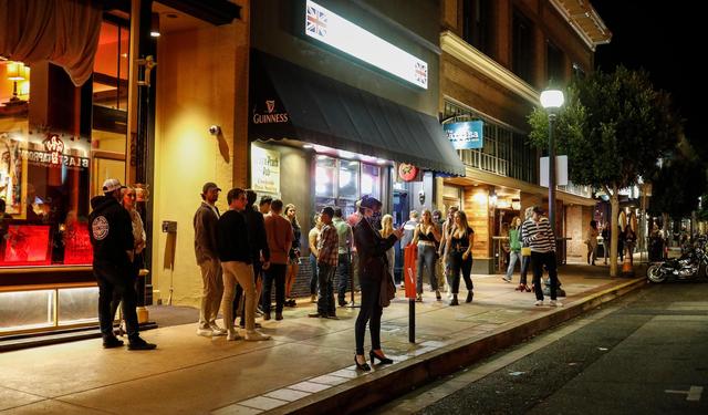A long line starts in front of Frog and Peach Pub in San Luis Obispo.
